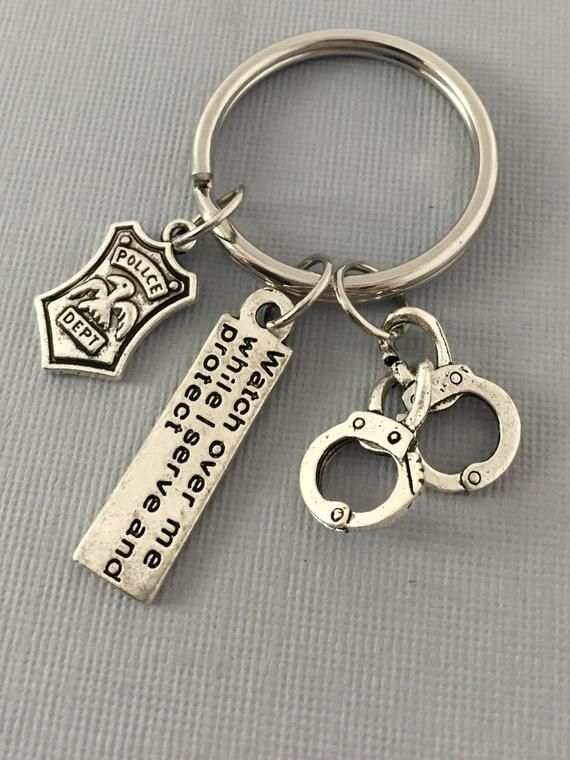 a keychain that has two handcuffs and a bottle opener on it with the words,