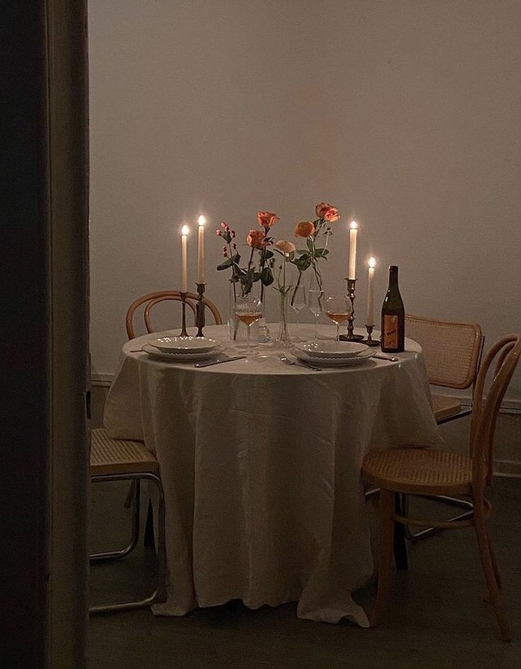 a table with candles and flowers on it in the middle of a dining room area