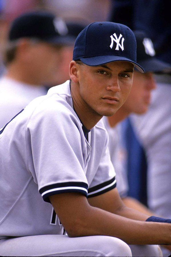 a baseball player sitting in the dugout during a game