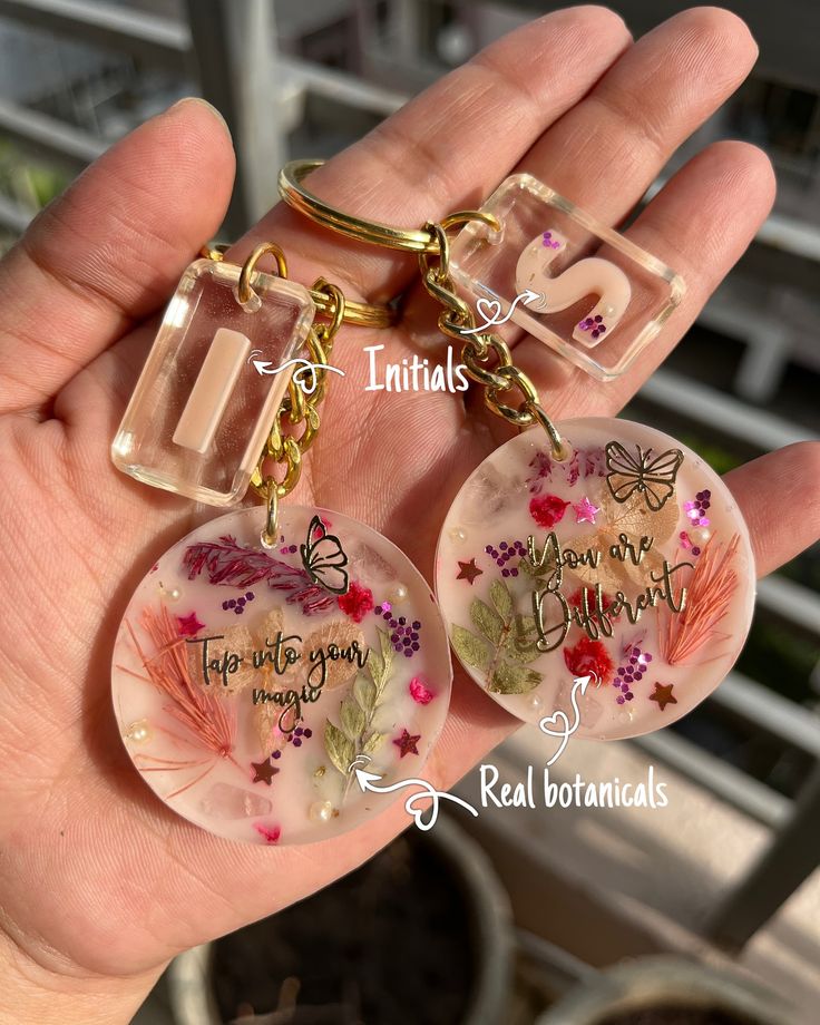 two keychains with words on them in the palm of someone's hand