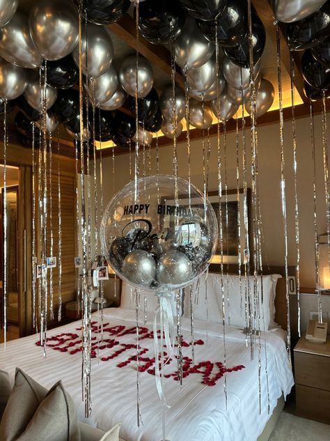 a bedroom decorated with black and silver balloons