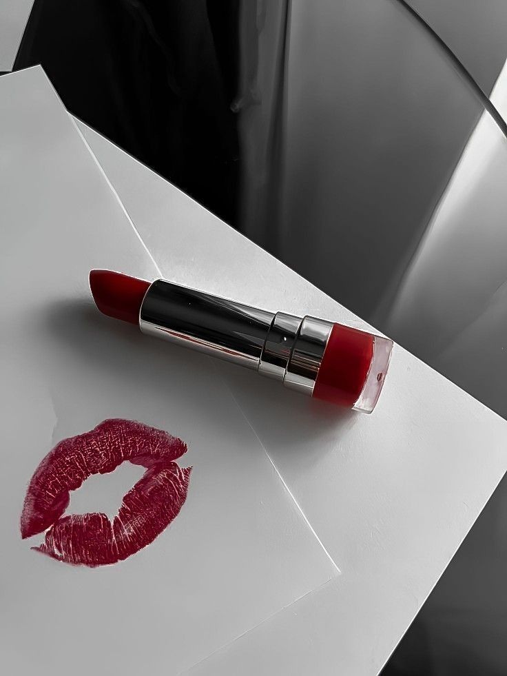 a red lipstick is laying on top of an envelope