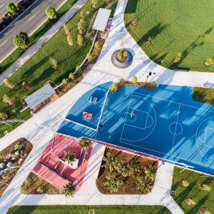 an aerial view of a basketball court in the middle of a park