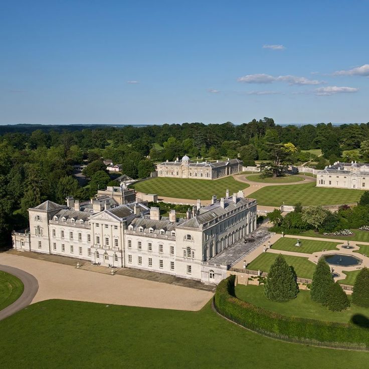 an aerial view of a large white building surrounded by trees