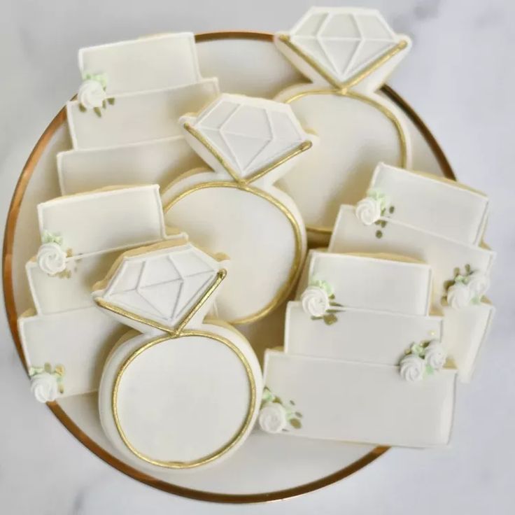 decorated cookies on a plate with white and gold decorations