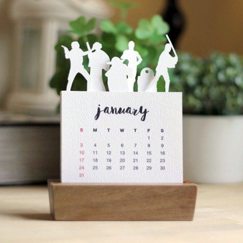 a desk calendar with figurines on it