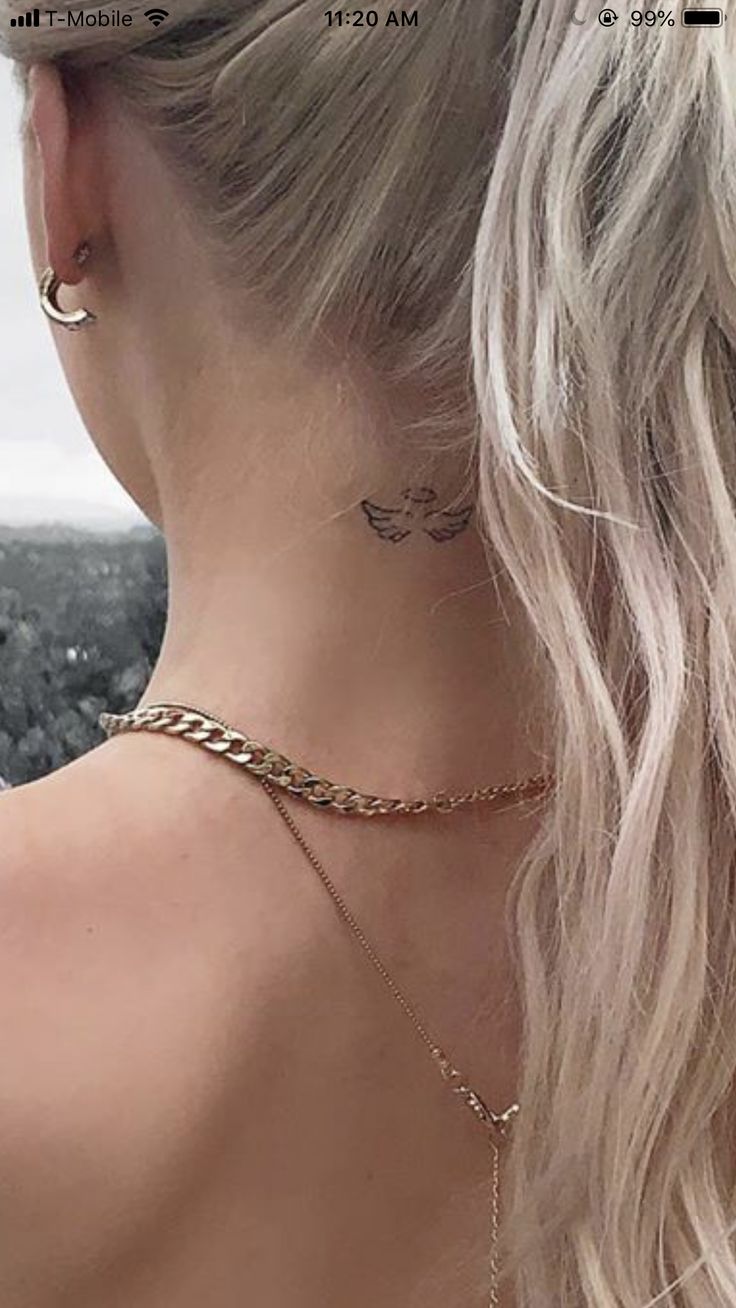 the back of a woman's neck wearing a gold chain choker and earrings