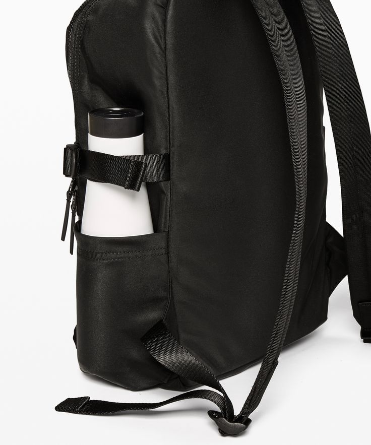 a black backpack with a water bottle in the back pocket and strap around the bottom