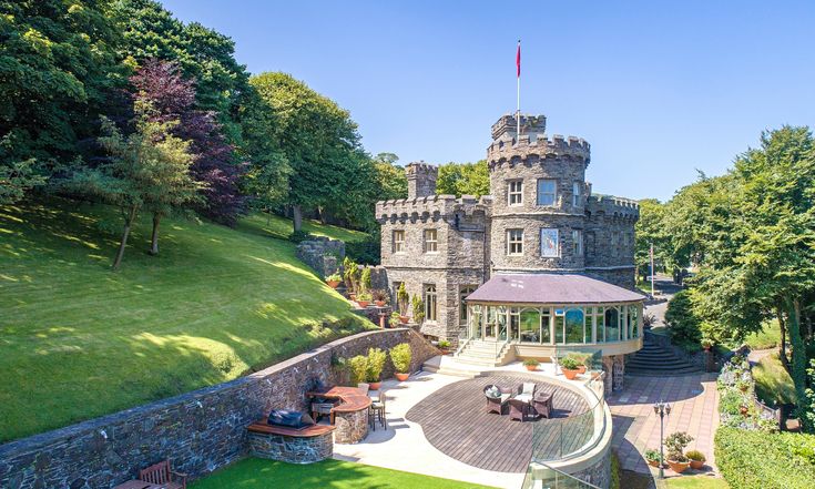 an aerial view of a castle like building in the middle of a lush green park