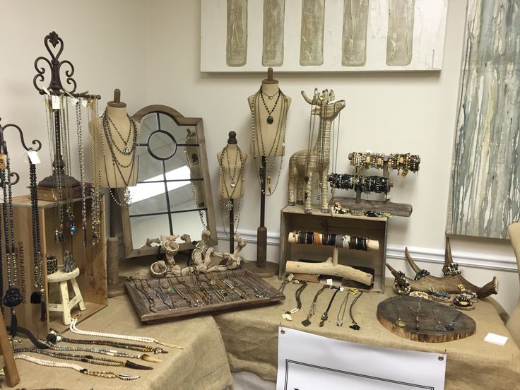 an assortment of jewelry is displayed on a table in front of a mirror and other items