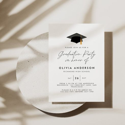 a graduation party card with a black and gold tassel on the front, next to a white plate