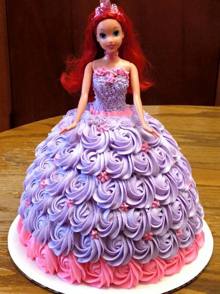 a doll cake with purple and pink frosting