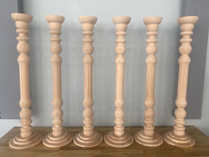 four wooden candlesticks lined up on a table