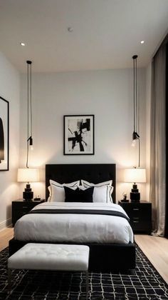 a bedroom with white walls, black and white bedding and pictures on the wall