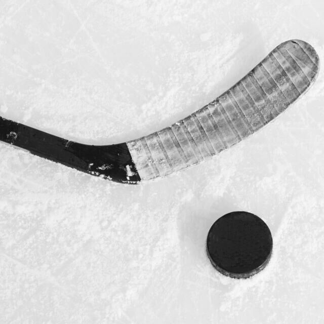 an ice hockey goalie's stick and puck laying in the snow next to it