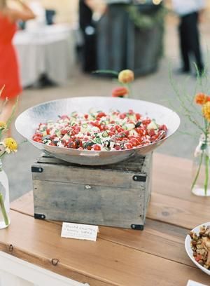 a table topped with lots of food and vases filled with flowers on top of it