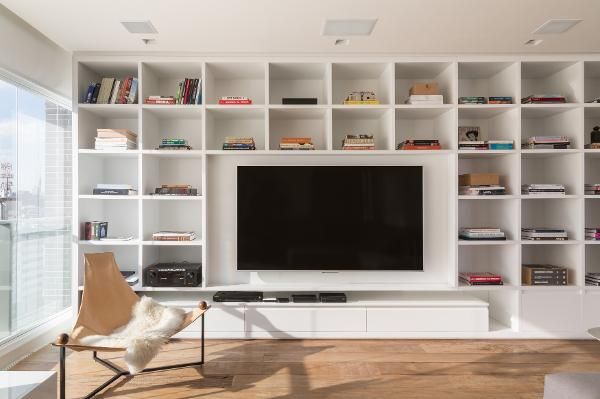 a living room filled with furniture and a flat screen tv mounted on a white wall