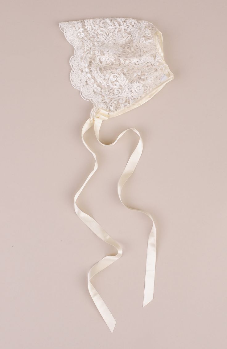 a white bridal garter hanging on a wall next to a ribbon tied around it