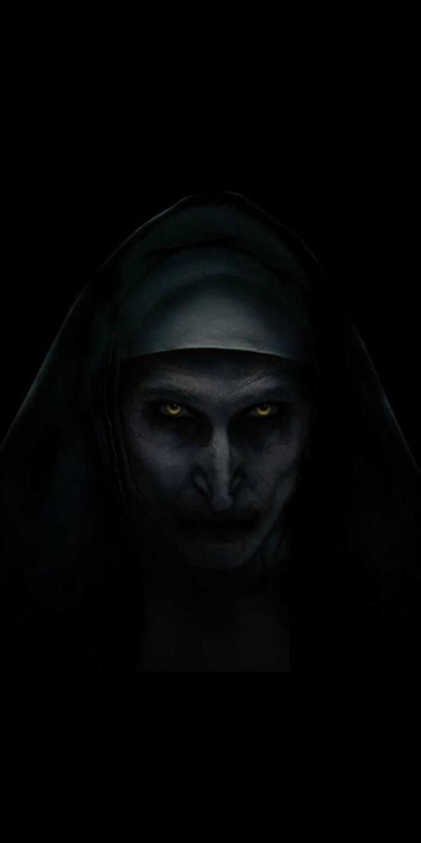 an evil nun with glowing eyes in the dark