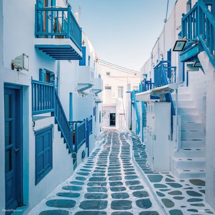 an alleyway with blue and white buildings on both sides, leading up to the second floor