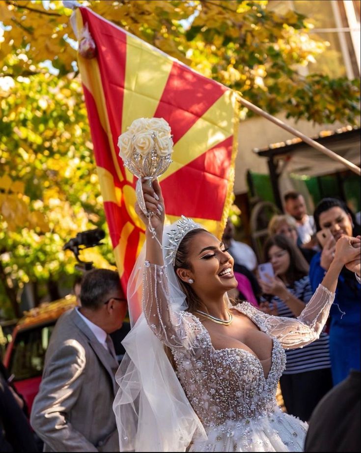 a woman in a wedding dress holding up a flag