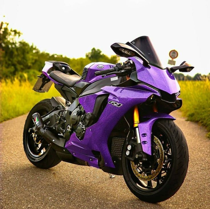 a purple motorcycle parked on the side of a road