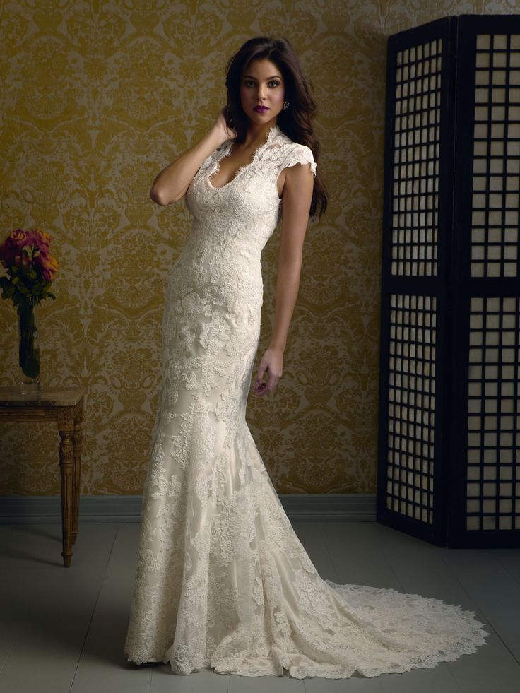 a woman in a wedding dress posing for the camera with her hand on her hip