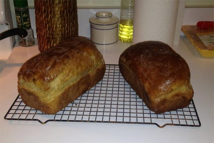 two loaves of bread sitting on top of a cooling rack