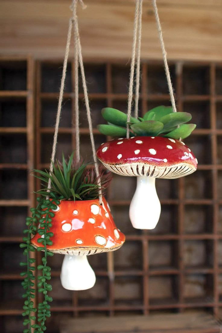 two hanging mushrooms with plants in them