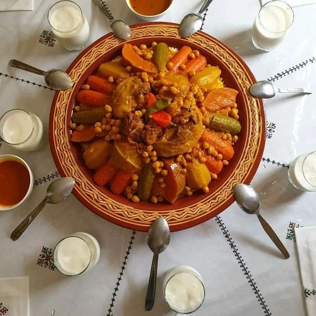 a plate full of vegetables and sauces on a table with silverware around it