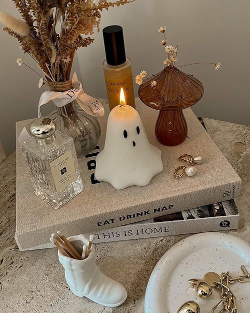 a table topped with books and candles on top of a counter next to a white plate