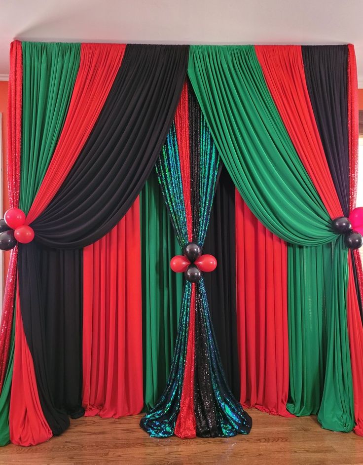 a room decorated with red, black and green drapes