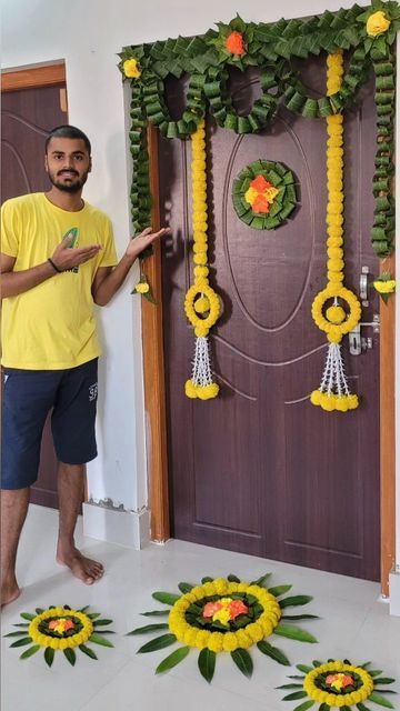 a man standing in front of a door decorated with yellow flowers and green garlands