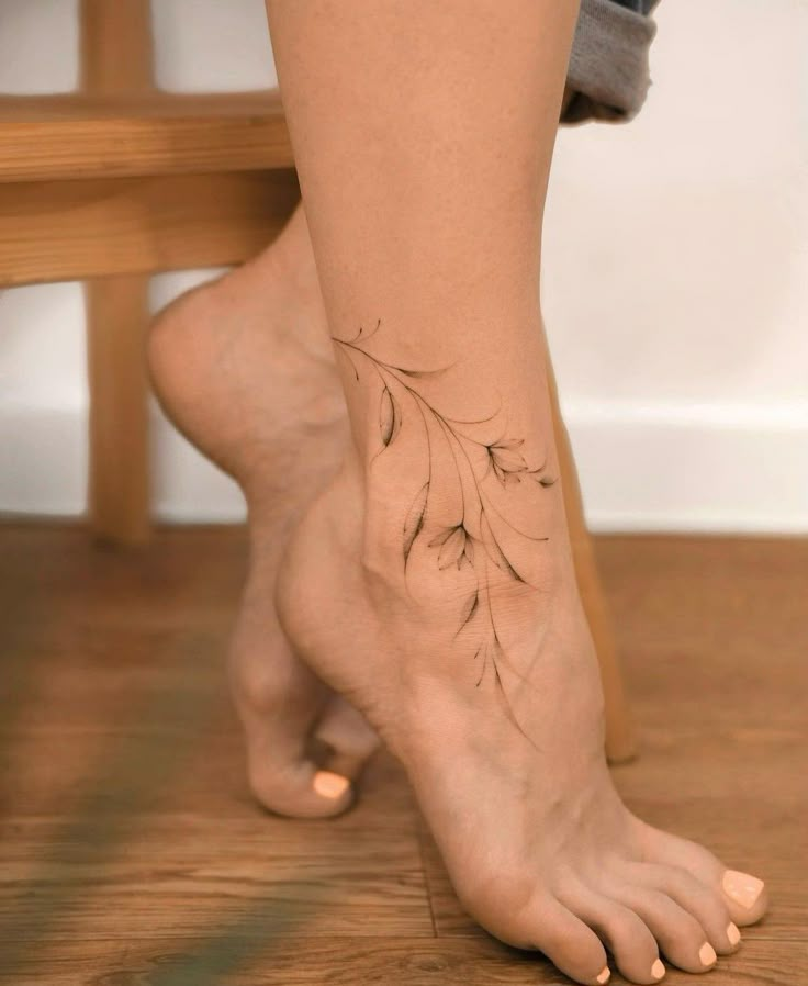 a woman's bare foot with a tattoo on her left leg and leaves on the right side