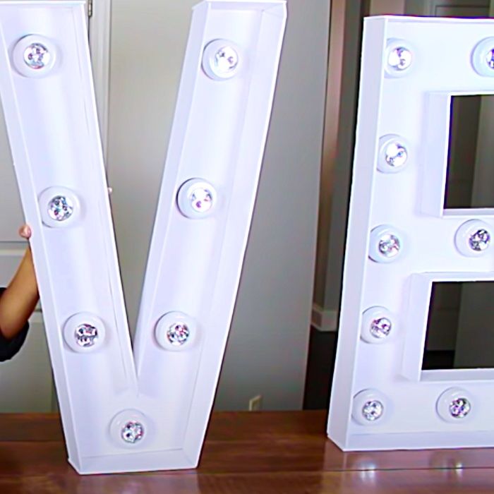 a young boy is standing next to two large letters