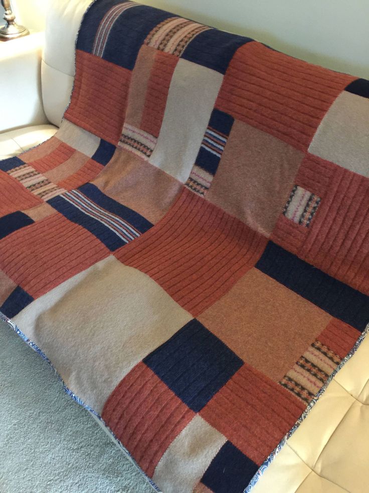 an orange and blue blanket sitting on top of a couch