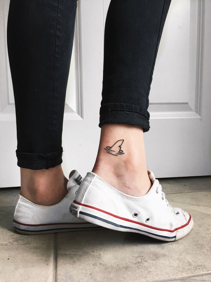 a woman's foot with a small bird tattoo on her left ankle and the bottom part of her shoe