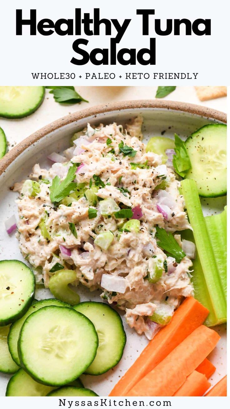 healthy tuna salad with cucumbers, carrots and celery on a white plate