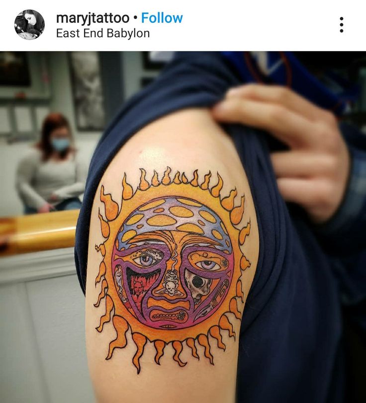 a person with a sun tattoo on their arm