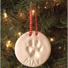 a ceramic ornament hanging from a christmas tree with the word paw on it