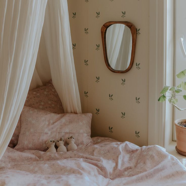 a bedroom with a bed, mirror and potted plant