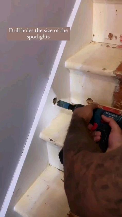 a man is using a drill to paint the stairs