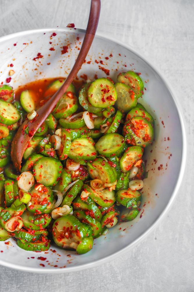 a white bowl filled with green vegetables and sauce