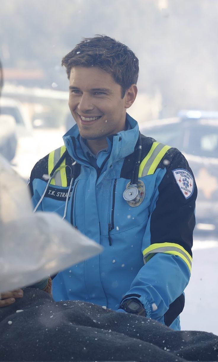 a man in a blue jacket smiles at the camera