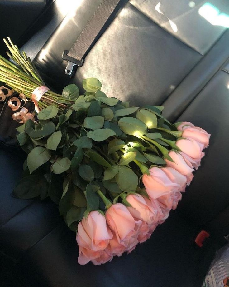 pink roses and greenery in the back seat of a car