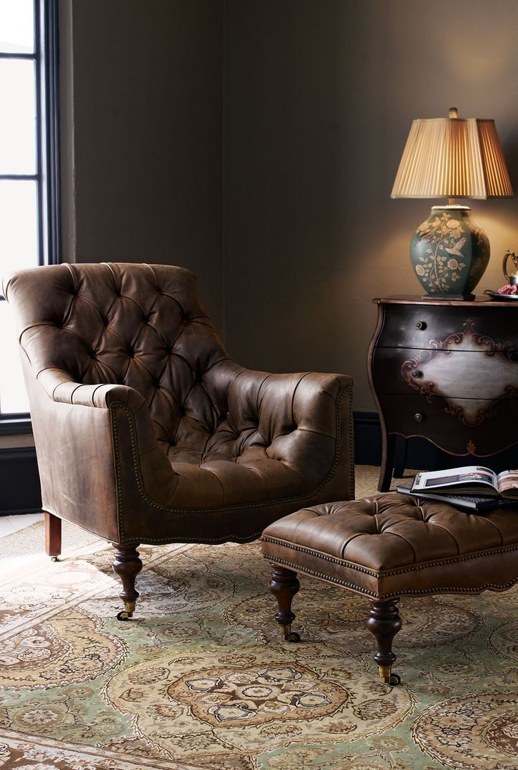 a chair and ottoman in a room with a large rug on the floor next to a window