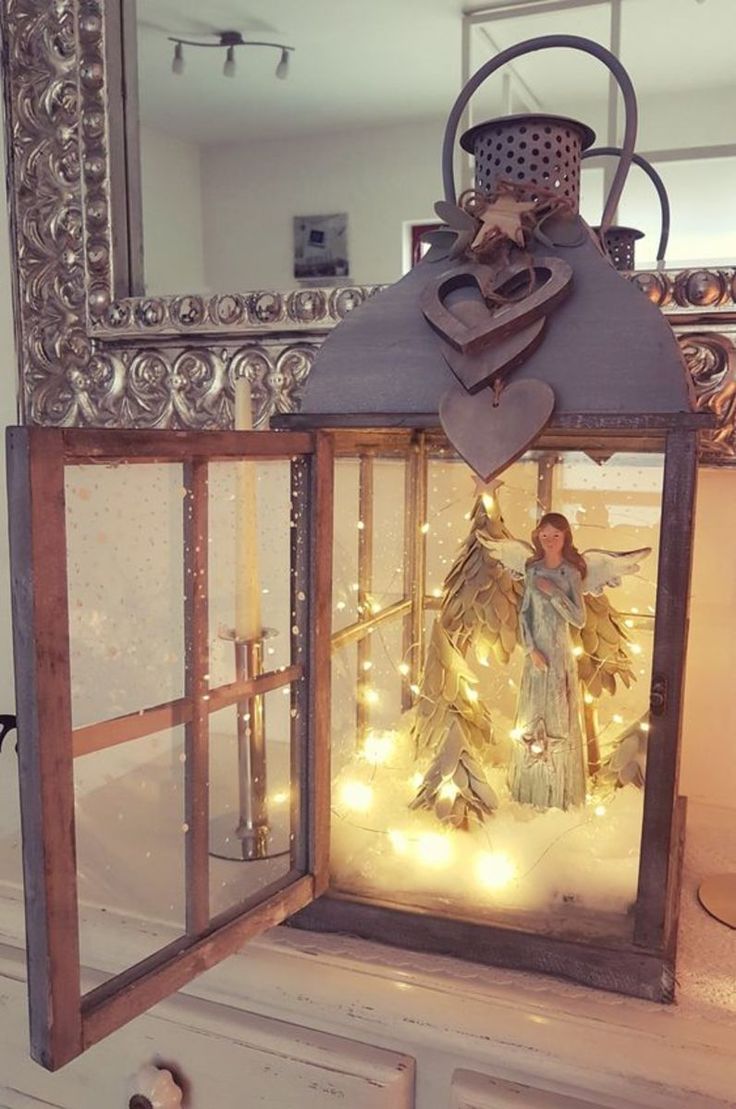 a lighted lantern with angel figurine in it