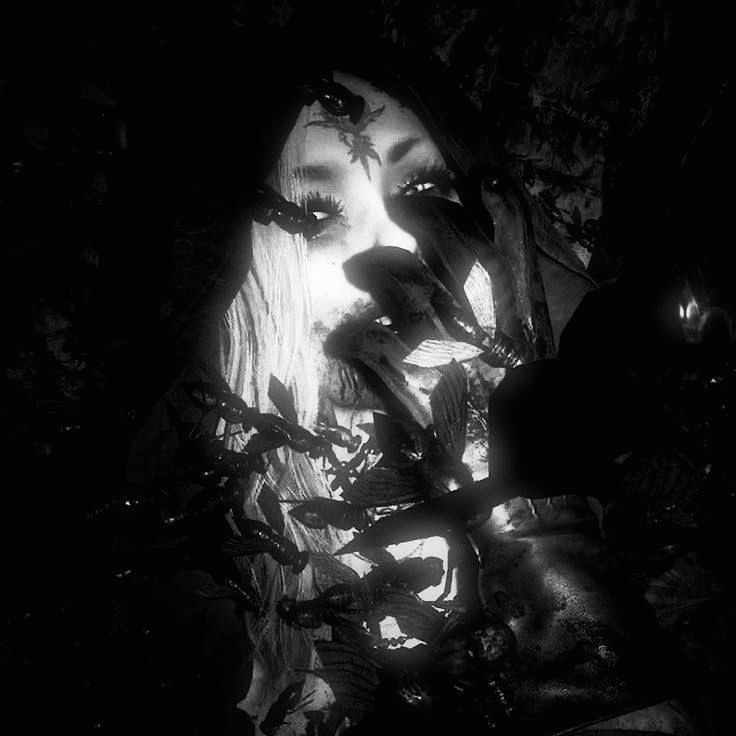 a woman with her eyes closed in the dark, surrounded by leaves and branches is staring into the camera