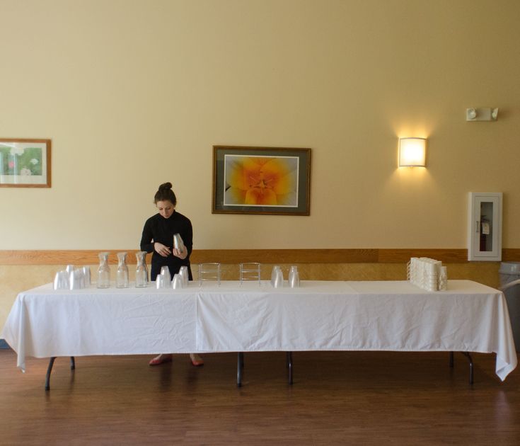 a woman sitting at a table with several glasses on it