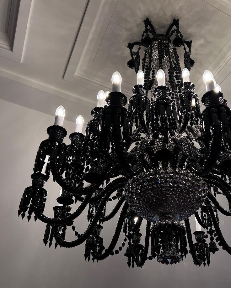 a chandelier hanging from the ceiling in a room with white walls and ceilings